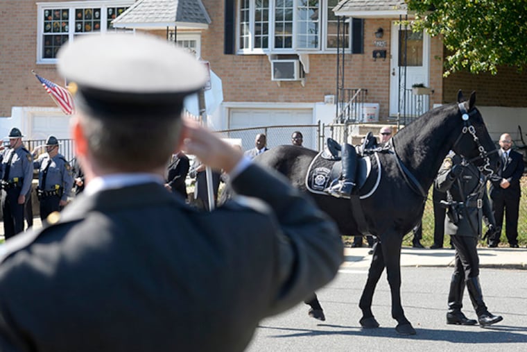 A riderless horse passes in front of Pennsylvania State Troopers in formation outside Christ the King Church in Northeast Philadelphia October 6, 2014, to start the funeral procession after mass and services for Trooper David Kedra who was shot and killed during a training exercise last week. ( TOM GRALISH / Staff Photographer )