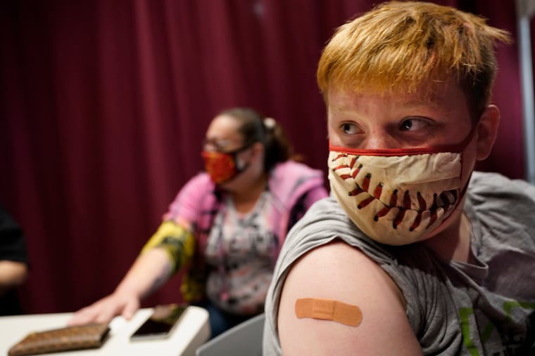 Jacob Conary, 15, listens to advice from a medical assistant after receiving his first shot of the COVID-19 vaccination in Auburn, Maine.