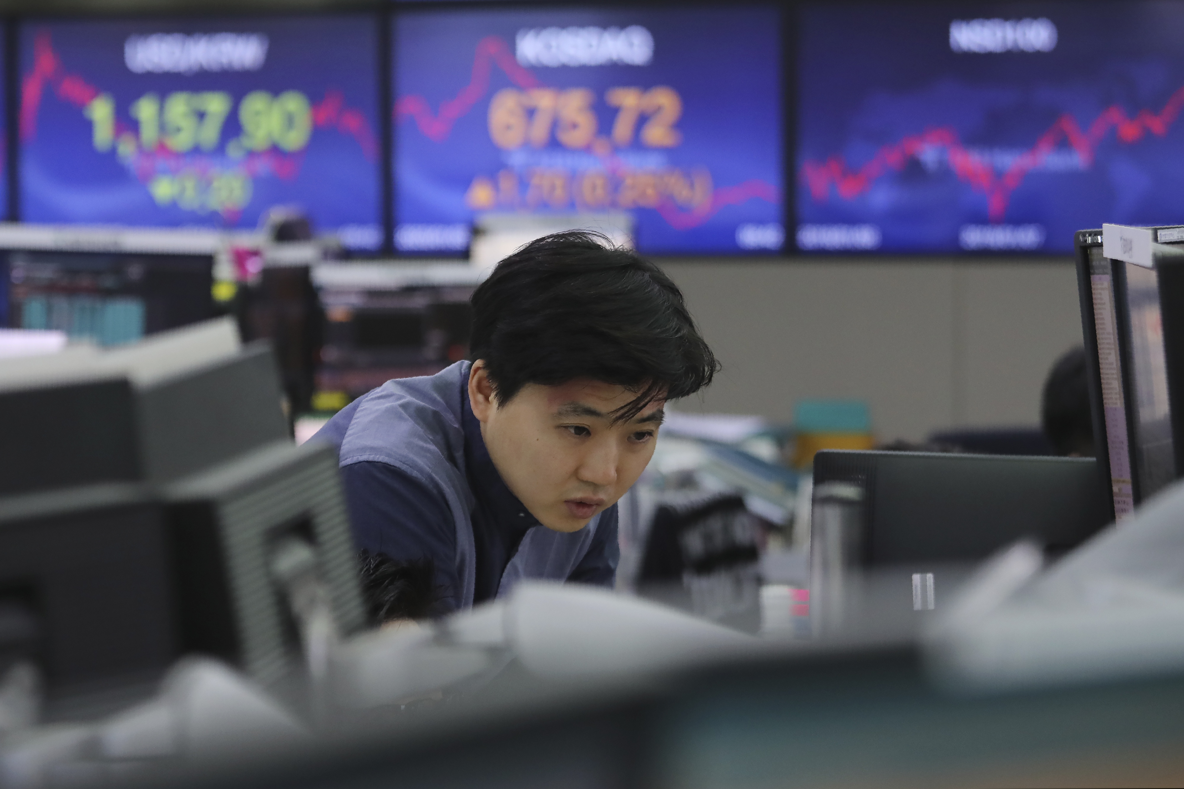 A currency trader watches monitors at the foreign exchange dealing room of the KEB Hana Bank headquarters in Seoul, South Korea, Friday, Jan. 3, 2020. Asian stocks were mixed Friday and oil prices surged after an Iranian general was killed by U.S. forces in Iraq.