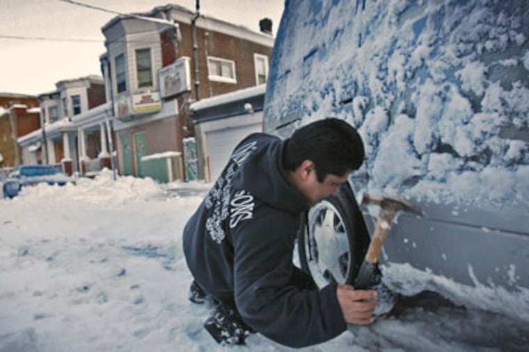 Juan Abundis of Philadelphia attempts to dig his rear wheel drive Ford Astro minivan out of the ice on Thursday morning at N. 5th St. Street on Thursday February 11, 2010. (Alejandro A. Alvarez / Staff Photographer)