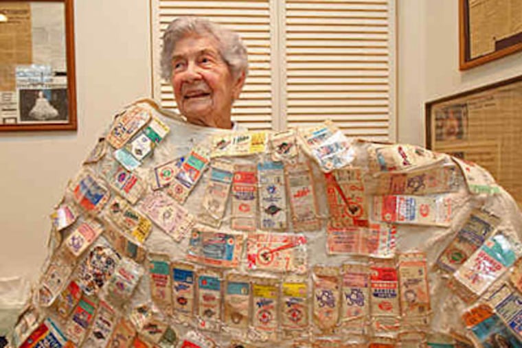 Jessie Foyle holds up one of her three sweaters that have her decades of World Series tickets sewn onto them. (Michael Bryant / Staff Photographer)