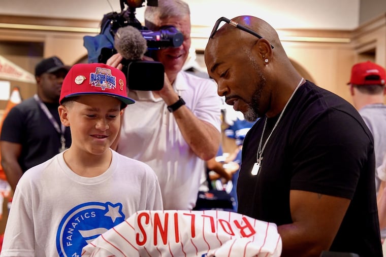Jimmy Rollins helps Braxton Ham, 11, shop at Mitchell & Ness for a private Fanatics shopping experience.
