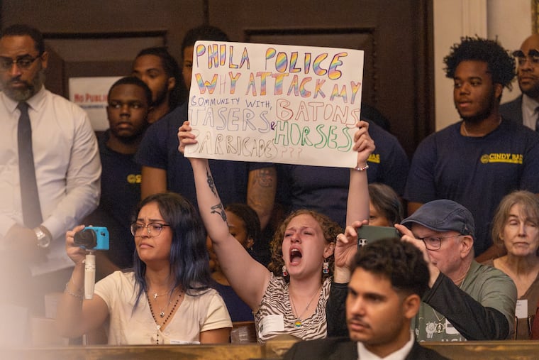 Kristianna Lewis (center) chants inside the chamber at City Hall on Thursday, June 11, 2026.