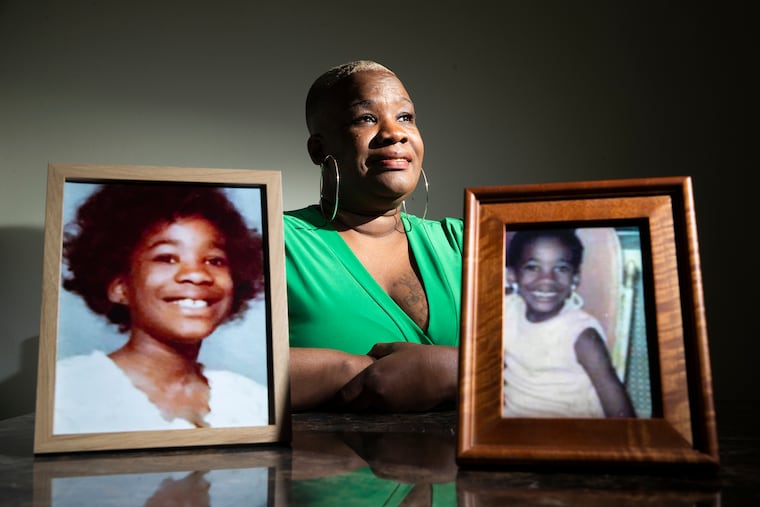 Cheryl Edwards with pictures of herself as a young girl, in a photograph from 2021 when she came forward to share her story with the Inquirer.