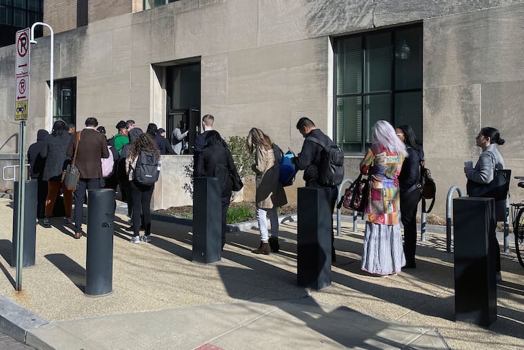 Hundreds of employees wait in line wrapped around the outside of the Health and Human Services headquarters building on Tuesday, April 1, 2025, in Washington.