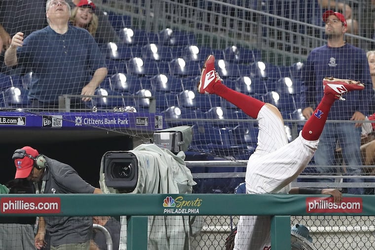 Phillies third baseman Maikel Franco flips over a railing as he goes after a foul ball hit by Adam Eaton of the Nationals in the eighth inning at Citizens Bank Park on Tuesday night.