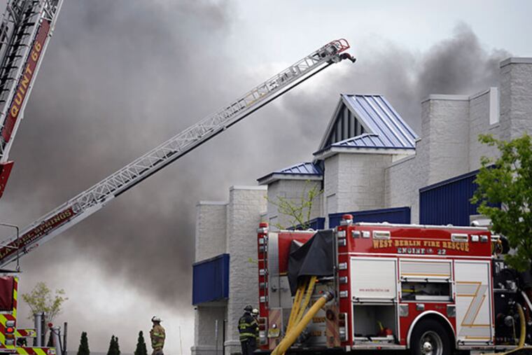 Firefighters work to control a fire in a building in West Berlin, N.J., Thursday, May 8, 2014. The mutli-alarm fire started in Resintech, a 75,000-square-foot manufacturing complex for products to treat water and wastewater. (AP Photo/Mel Evans)