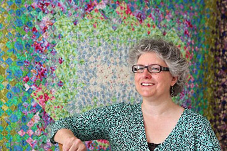 Joanne Cleaver stands next to one of her quilt displays at her home in Chicago. Cleaver has been sewing since she was 12 and started quilting at 14. (AP Photo/Kiichiro Sato)