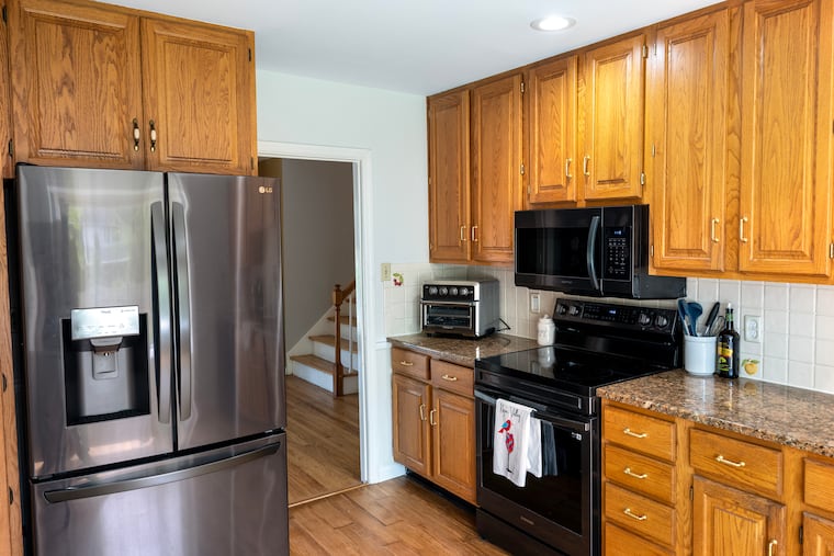 The kitchen in Valerie Rossi's home. She kept the cabinets, but painted the walls, cleaned up the tile backsplash, and updated the hadrware.