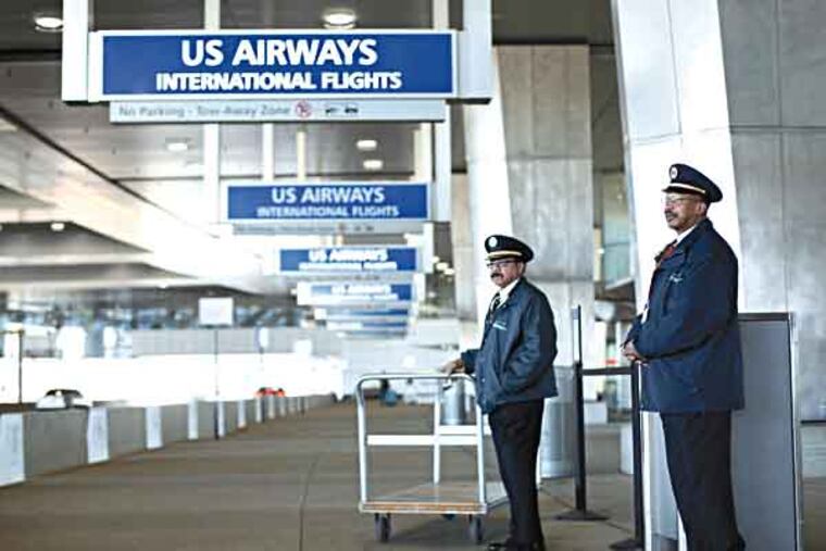 Skycaps Angelo Reid, right, and George Hill do not work for the city or US Airways, but for a subcontractor. Activists held a prayer vigil at City Hall over wage standards. (AP Photo/Matt Rourke)