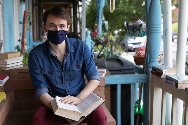 Yannick Trapman-O’Brien, an improv actor, poses for a portrait on the porch of his home in University City. His play, "Telelibrary," which he's been performing over the phone during the pandemic, has a waiting list of more than 100 people.