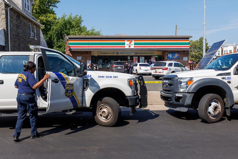 Crime Scene Unit officers gathering evidence at the 7-Eleven on Torresdale Avenue and Disston Street on Thursday. This was the scene of a fatal shooting.
