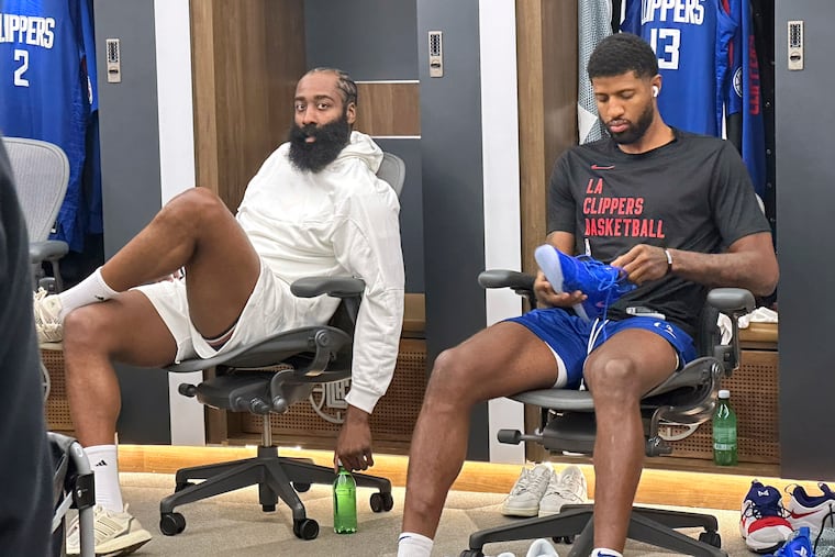 James Harden (left) sits next to Los Angeles Clippers forward Paul George as visits the locker room before Tuesday's game against the Orlando Magic.
