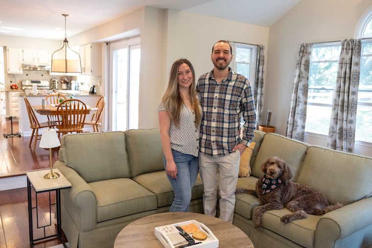 Chris and Tessie Payne pose for portrait with their dog, Mocha, in the living room of their home in West Chester.