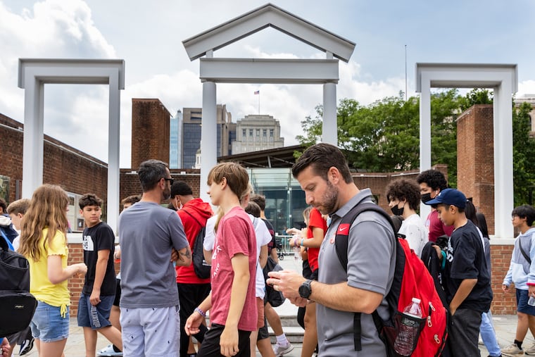 Visitors to Independence Mall walk past the President's House at Sixth and Market Streets in June 2022.