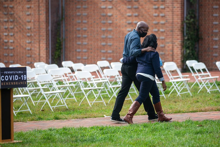 Carol Lewis and her brother Jeff Green walk away from a podium on Independence Mall in October after sharing the story their father, Hiram Green, who died of COVID-19 at 86.