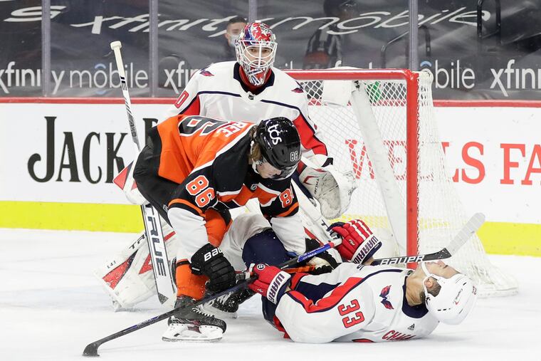Joel Farabee takes down Washington defenseman Zdeno Chara as goaltender Ilya Samsonov looks on in the second period on Saturday.