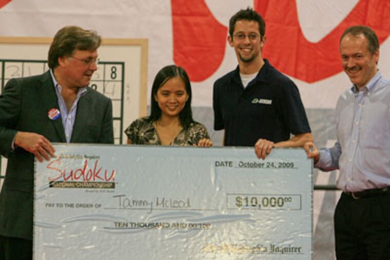 Brian Tierney, publisher of the Philadelphia Inquirer (left) , Morgan Haro from Hudson Entertainment (3rd from left) and Will Shortz, host of the championships, present the winner's check to Tammy McLeod, from Los Angeles, Calif. (Akira Suwa / Staff Photographer )