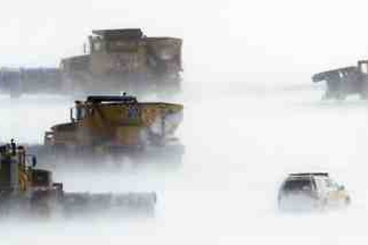 Crews clear runways at Philadelphia International Airport. The airport stayed open through the snowstorm, but hundreds of flights were canceled.