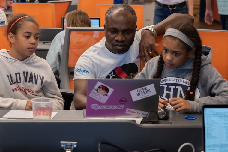 Stephen Osei-Akoto, of Slalom Consultanting, works with two pupils during "Storytelling with Data," a workshop on how to build and structure databases, load data into a modern reporting tool (Tableau), and design & create impactful data visualizations. The event was held in Philadelphia on Sept. 15, 2019.