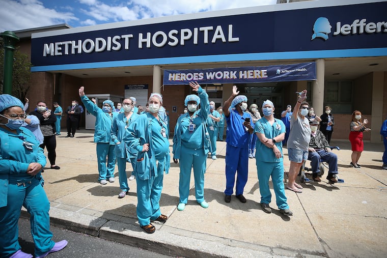 Medical staff gathered outside Jefferson Methodist Hospital in Philadelphia wave to a vehicle honking in support on Monday.