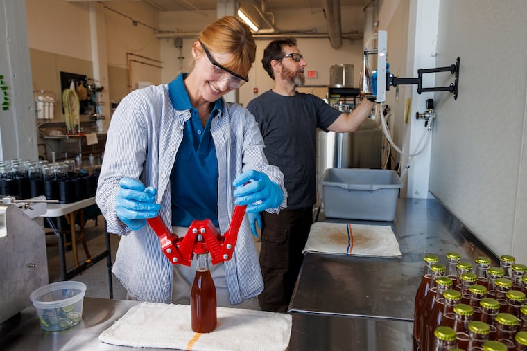 Cult of Trees owner Meredith Sheehy and employee Gordon Grubb work on bottling and carbonation for their line of zero-proof aperitifs in Kensington.