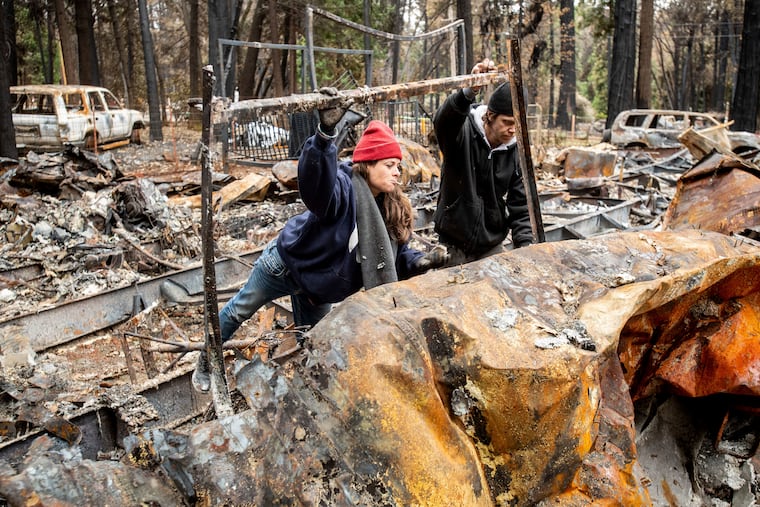 Sara Sullivan searches for belongings at her Magalia, Calif., home, destroyed by the Camp Fire, on Tuesday, Dec. 4, 2018. (AP Photo/Noah Berger)