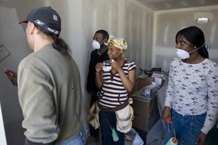 Chris Pisano, construction instructor for YouthBuild, helps Kevin Kennedy, Keliah Shelton and Sharita Paul paint a bedroom in North Philadelphia. ( Kevin Cook / Staff Photographer )