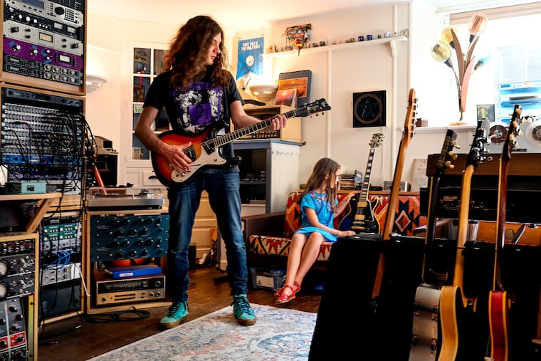 Kurt Vile in his basement studio at his home in Mt. Airy June 13, 2022 with his daughter Delphine. His record label sent him a cheesesteak sculpture in honor of his song "Pretty Pimpin" being streamed 100 million times.