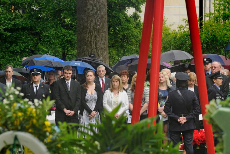 The family of Daniel Sweeney stands during Living Flame Memorial Service in Franklin Square May 2, 2012. Sweeney was one of two firefighters killed in the Kensington warehouse fire last month. ( TOM GRALISH / Staff Photographer )