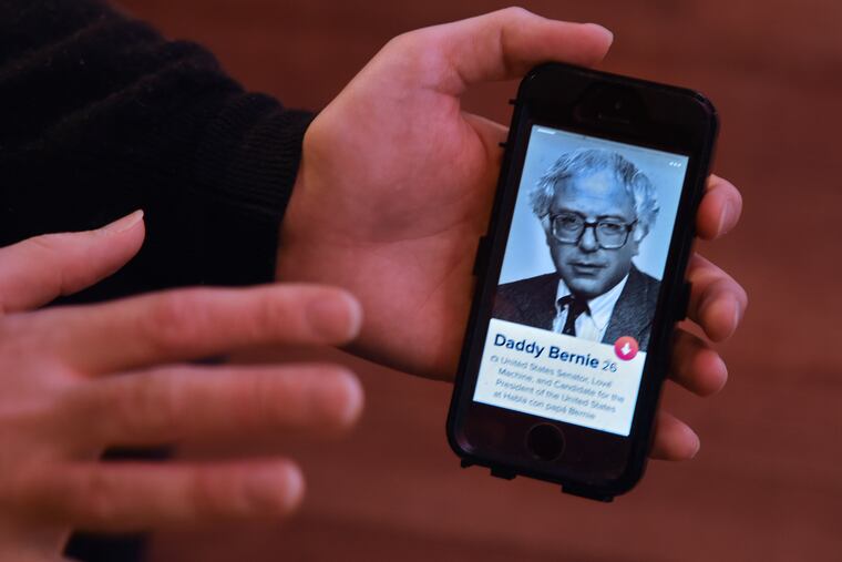 Alex Scheinberg swipes on his profile on Philly Tinder in his bedroom in his parents' Collingswood home, with his photo showing Bernie Sanders in 1991.