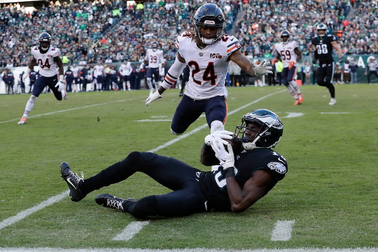 Eagles wide receiver Nelson Agholor rolling on the ground after catching the football past Chicago Bears cornerback Buster Skrine.