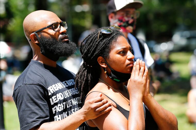 Irik Robinson (left) and his wife, Taslim Patterson, listen to speakers during a Rally for Political Prisoners at Malcolm X Park in West Philadelphia on Sunday.