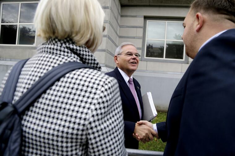 U.S. Sen. Bob Menendez, center, talks to supporters while arriving at the Martin Luther King, Jr., Federal Courthouse for his federal corruption trial, Thursday, Oct. 26 in Newark, N.J. (AP Photo/Julio Cortez)