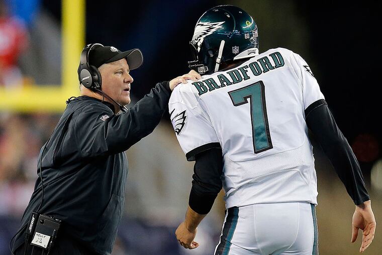 Eagles head coach Chip Kelly talks to Sam Bradford.