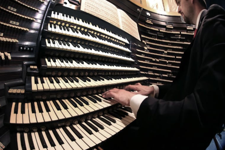 Steven Ball plays the Boardwalk Hall organ, the largest pipe organ in the world. "It was designed to be a library of all sound," he says. (TOM BRIGLIA/For The Inquirer)