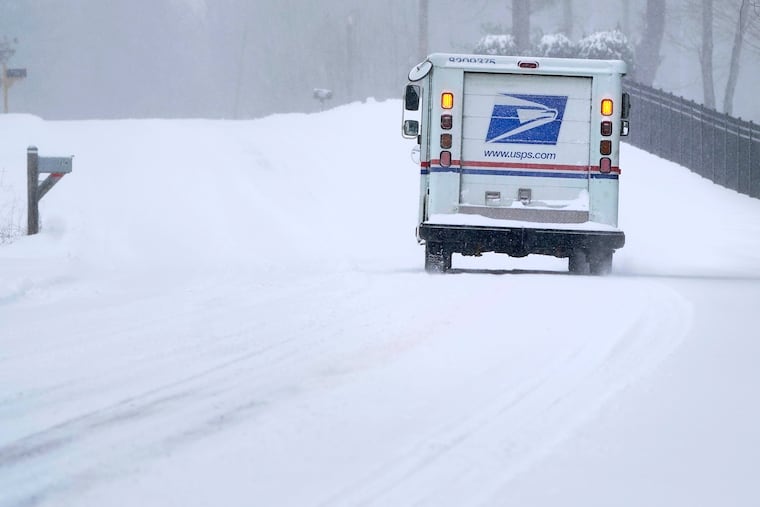 A U.S. Postal Service delivery vehicle heads up a hill on a snow covered road during a winter storm in Derry, N.H., Friday, Feb. 25, 2022.