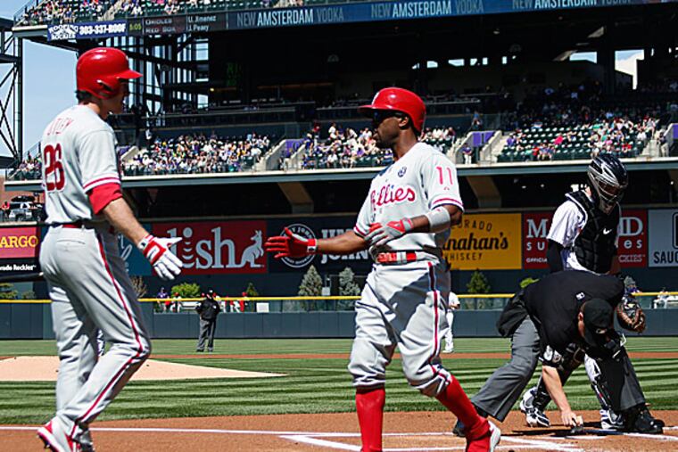 The Phillies' Chase Utley congratulates teammate Jimmy Rollins after his solo home run in the first inning. (David Zalubowski/AP)