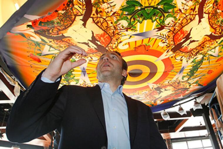 Reed Cordish, VP of The Cordish Company, walks underneath a mural in the PBR Bar and Grill. (Alejandro A. Alvarez/Staff Photographer)