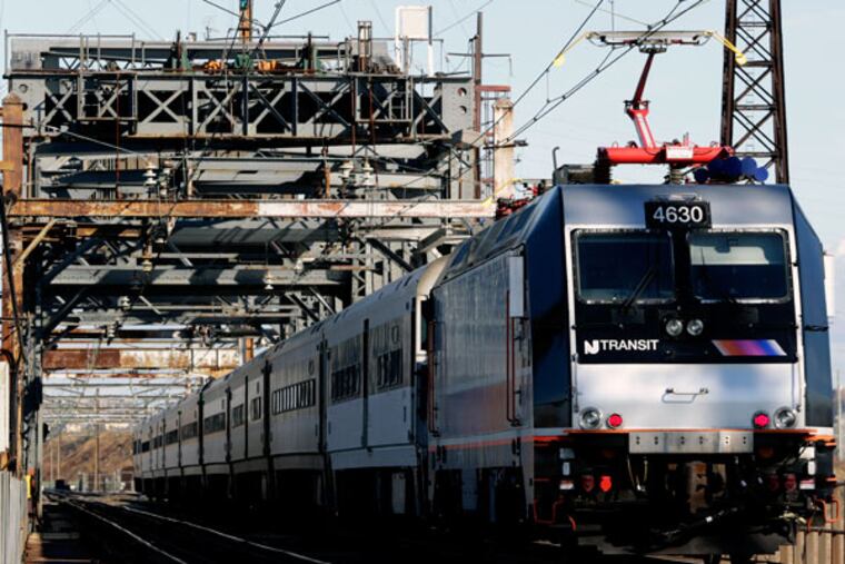In this photo taken Friday, Nov. 14, 2014, a New Jersey Transit train rides across a portal bridge in Kearny, N.J. (AP Photo/Julio Cortez)