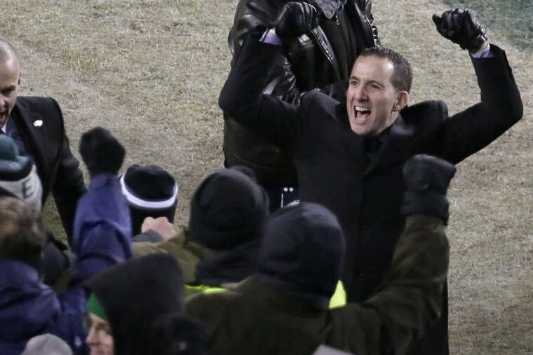 Eagles Howie Roseman runs off the field celebrating after the Eagles’ win over the Falcons on Saturday.