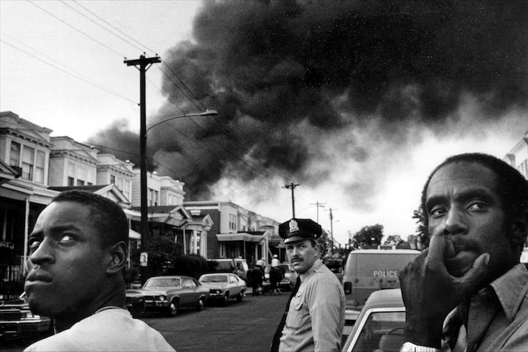 The corner of 62nd and Larchwood on May 13, 1985, as smoke pours out over the 6200 block of Osage Avenue after police dropped a bomb on MOVE headquarters.