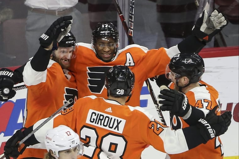 Flyers’ center Sean Couturier (left) celebrates his goal with teammates against the Red Wings in the team’s 4-3 win at the Wells Fargo Center.