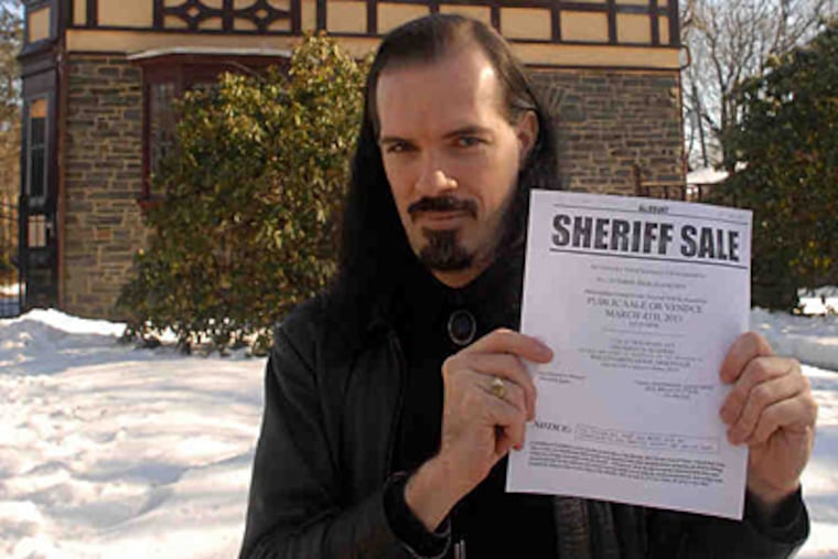 Patrick Rodgers at his Wynnefield Heights home with the "sheriff sale" declaration against the mortgage company. (Tom Gralish / Staff Photographer)