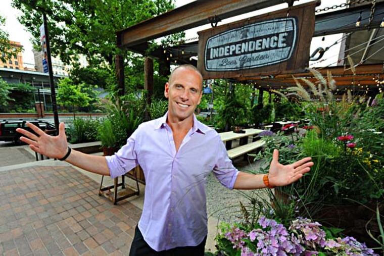 Michael Schulson, 41, is the owner of the new Independence Beer Garden, overlooking Independence National Historic Park (background) on 6th Street between Market and Chestnut Srs. opening July 15, 2014. ( CLEM MURRAY / Staff Photographer )