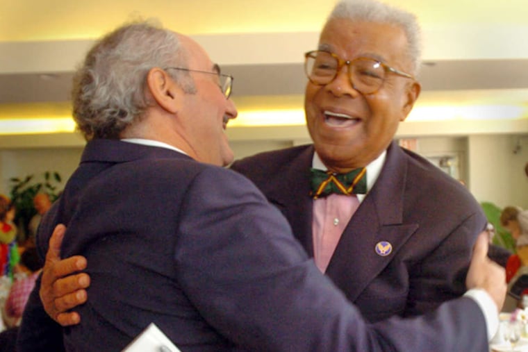 Chuck Stone (right) greets former Daily News editor Zack Stalberg during a reception at the Free Library in 2004. (G.W. MILLER III / FILE PHOTO)