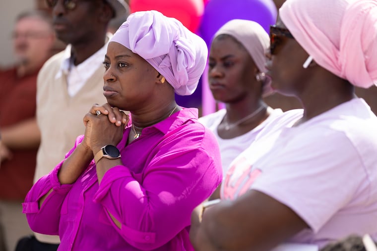 Tenneh Kromah (left), Fanta Bility’s mom, stands with Mariam Samoe, Fanta’s cousin, during a backpack giveaway at Sharon Hill School on Sunday.