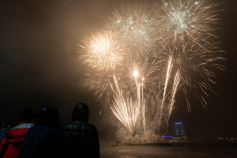 People gather to watch the Rivers Casino New Year’s Eve Firework show on the waterfront in Philadelphia on Dec. 31, 2022.