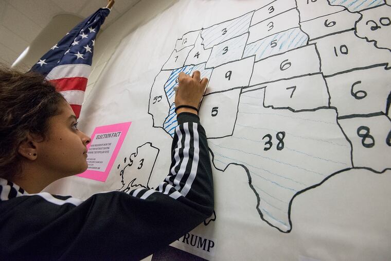 Mia Lemon, 13, an eighth grader at Skyline Middle School in Harrisonburg, Va., marks Nevada as a blue state as she counts ballots cast by her fellow students during the school's mock presidential election. The states' 2016 Electoral College votes are noted on the map.