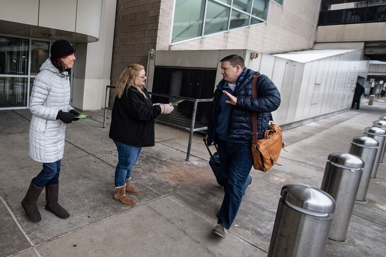 Air traffic controllers Kristen Laubach, left, and Cynthia Lowtther leaflet outside The Philadelphia International Airport to let people know about the shutdown and how they're working without pay.